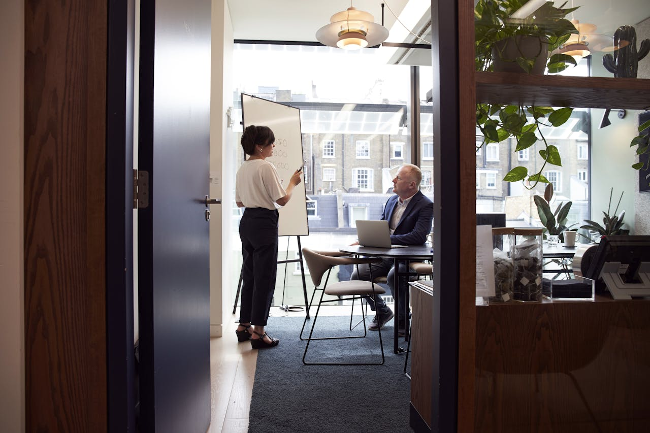 services-01 Colleagues engage in a strategic business meeting in a contemporary London office with city views.